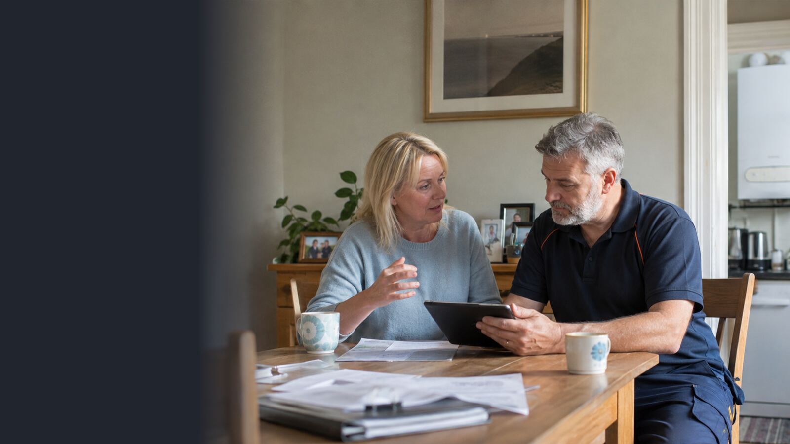 Heating engineer discussing boiler repair options with a woman homeowner