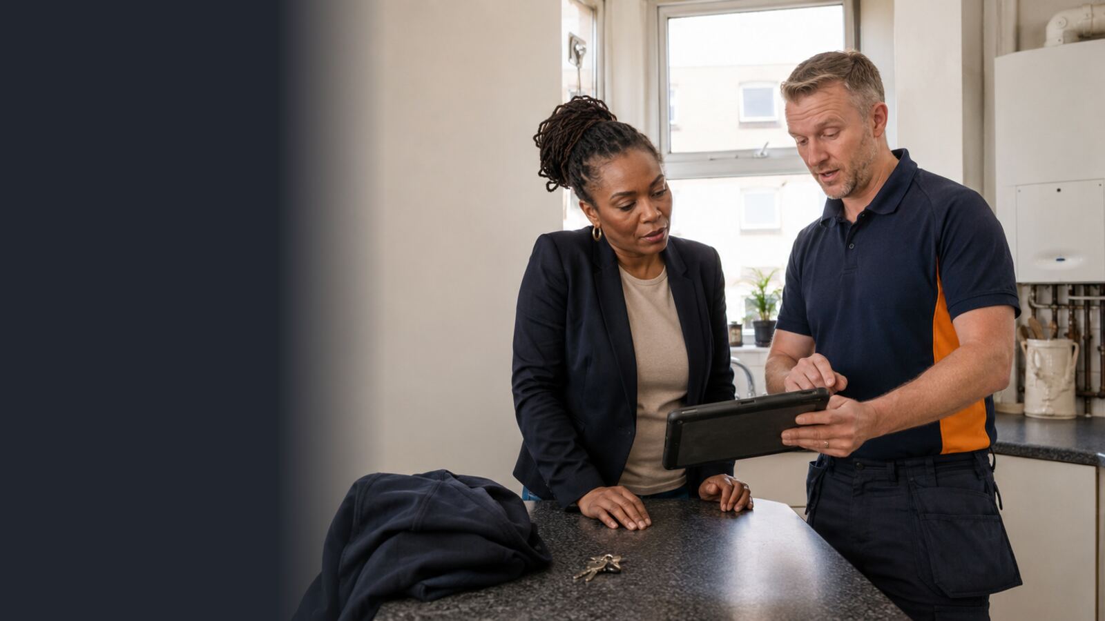 Heating engineer reviewing safety-check information with a woman property manager