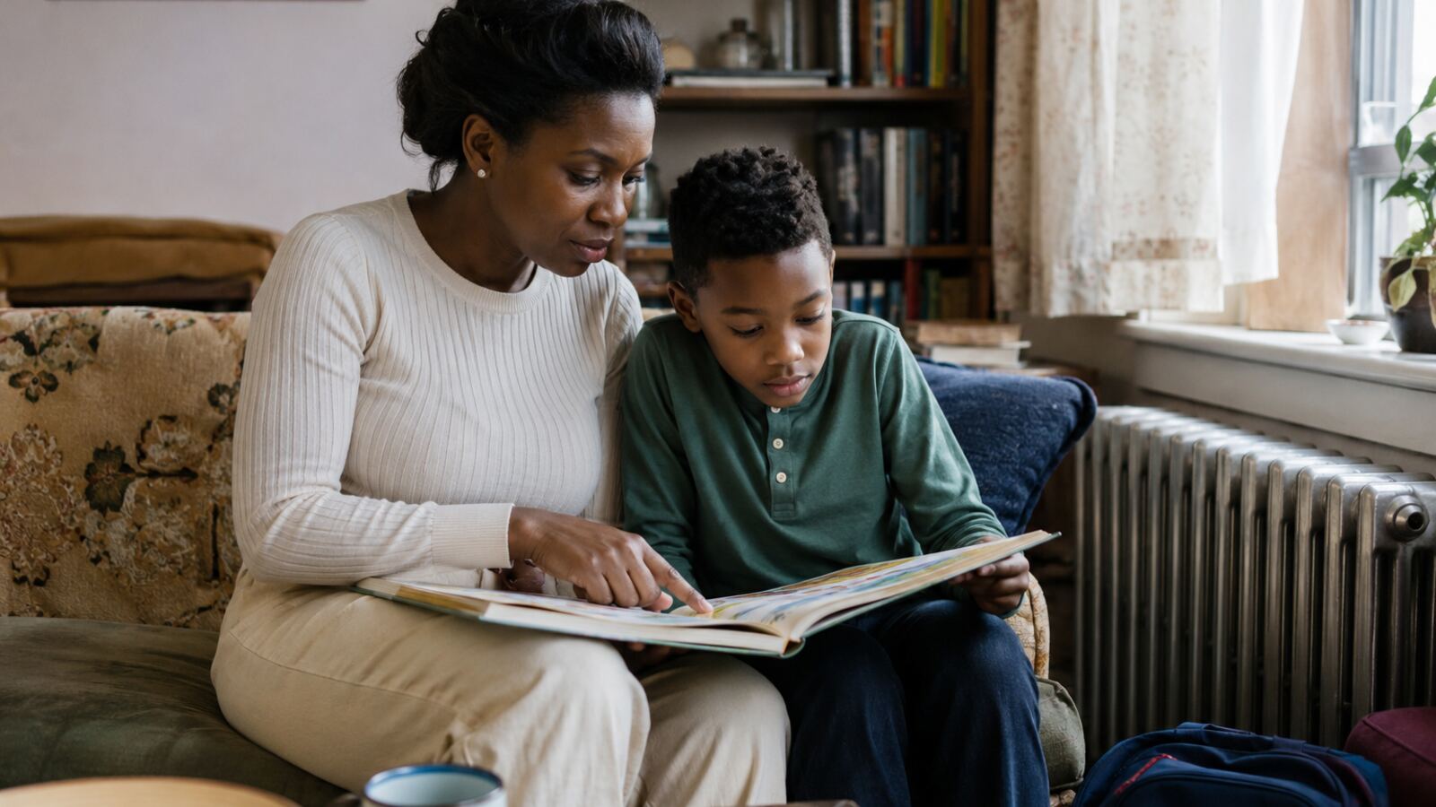 Mother and child reading together beside a radiator in a warm home